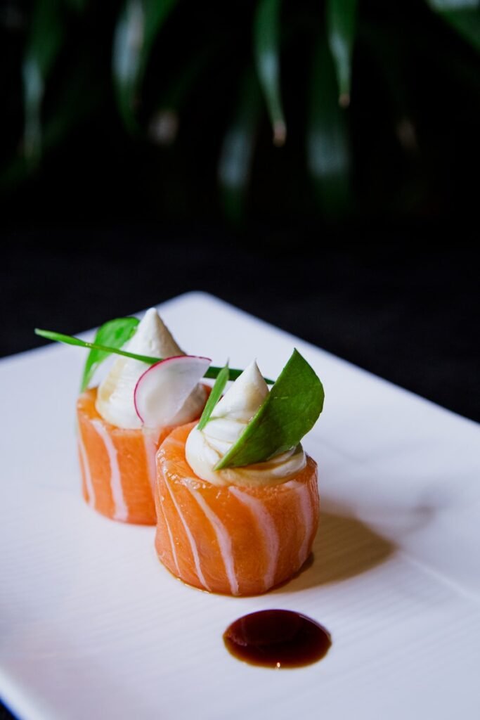 Uramaki Dragon Roll - a white plate topped with sushi covered in sauce