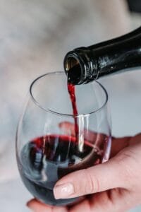person pouring wine on clear wine glass - Abocado ¿Qué es?